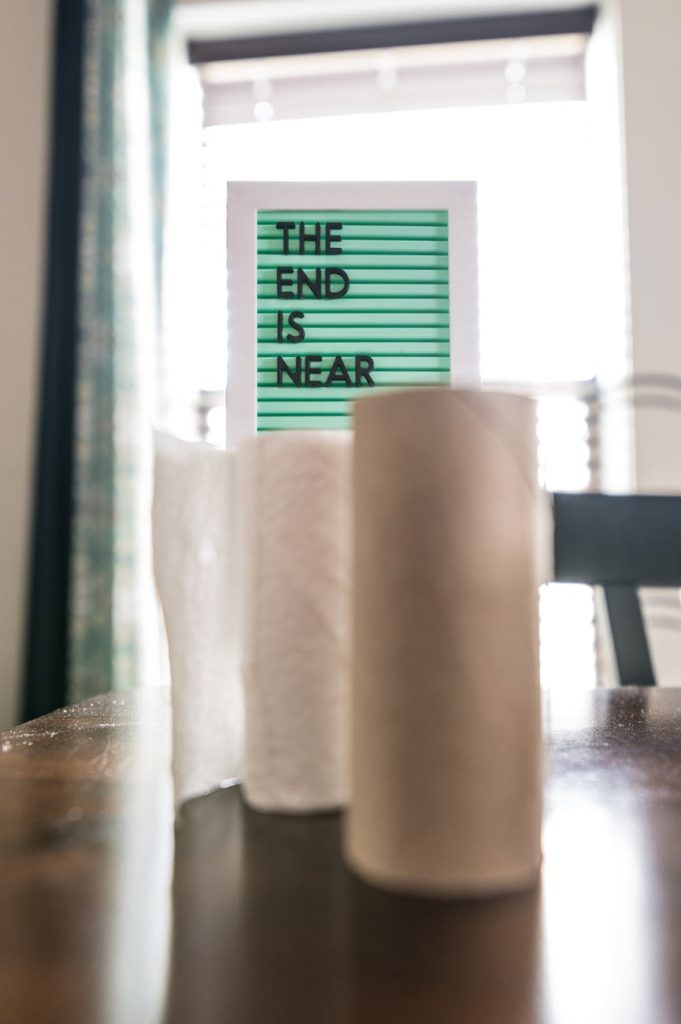 rolls of paper towels on table near board with lettering